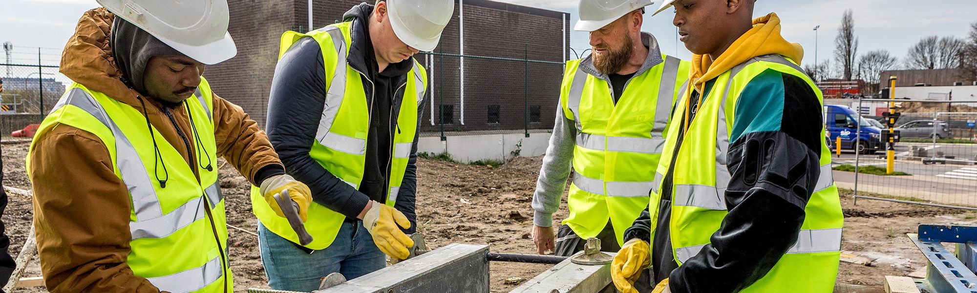 Vier bouwvakkers aan het werk op de bouwwerf.