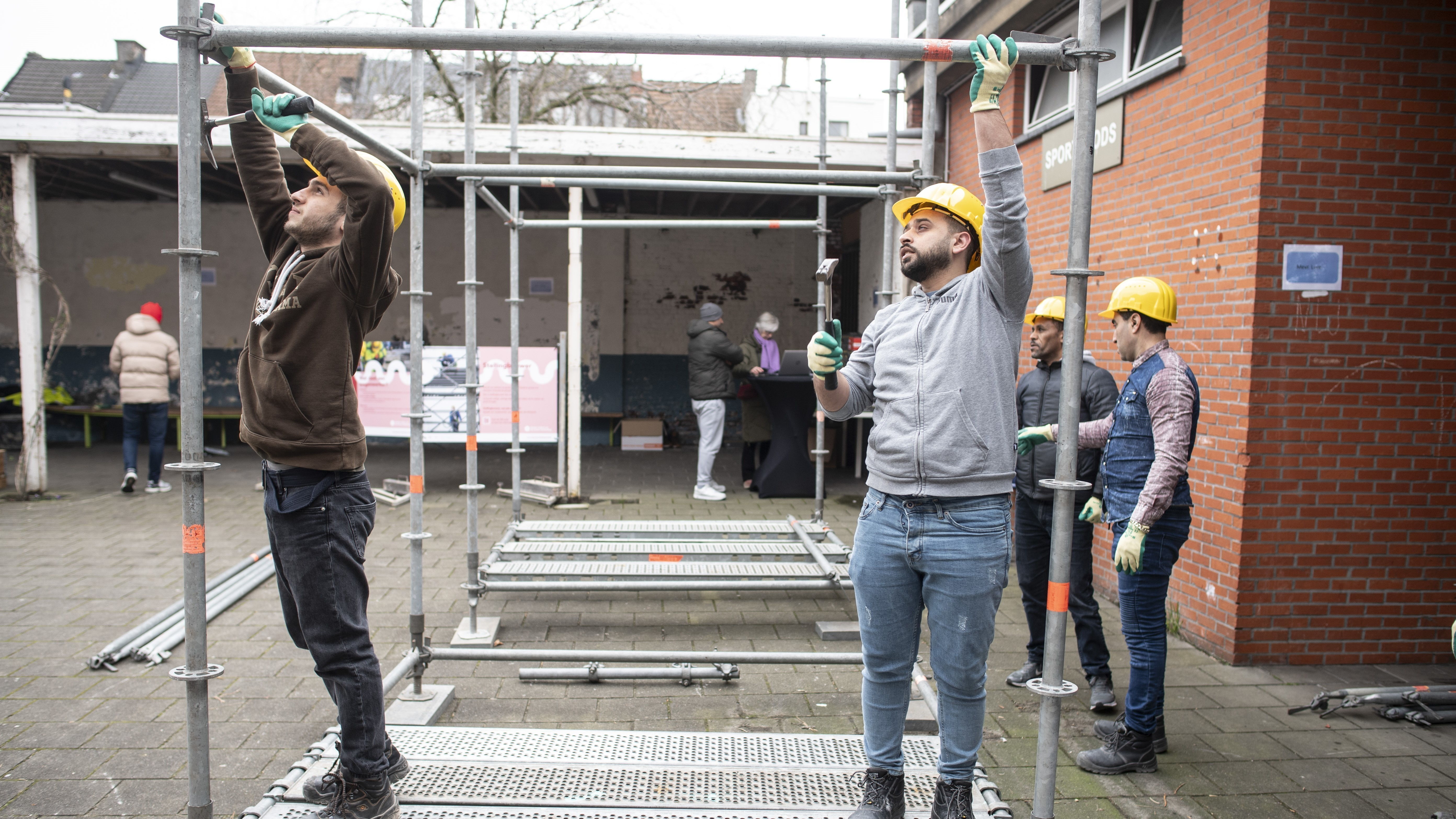 Deelnemers aan het werk tijdens de workshop stellingbouw.