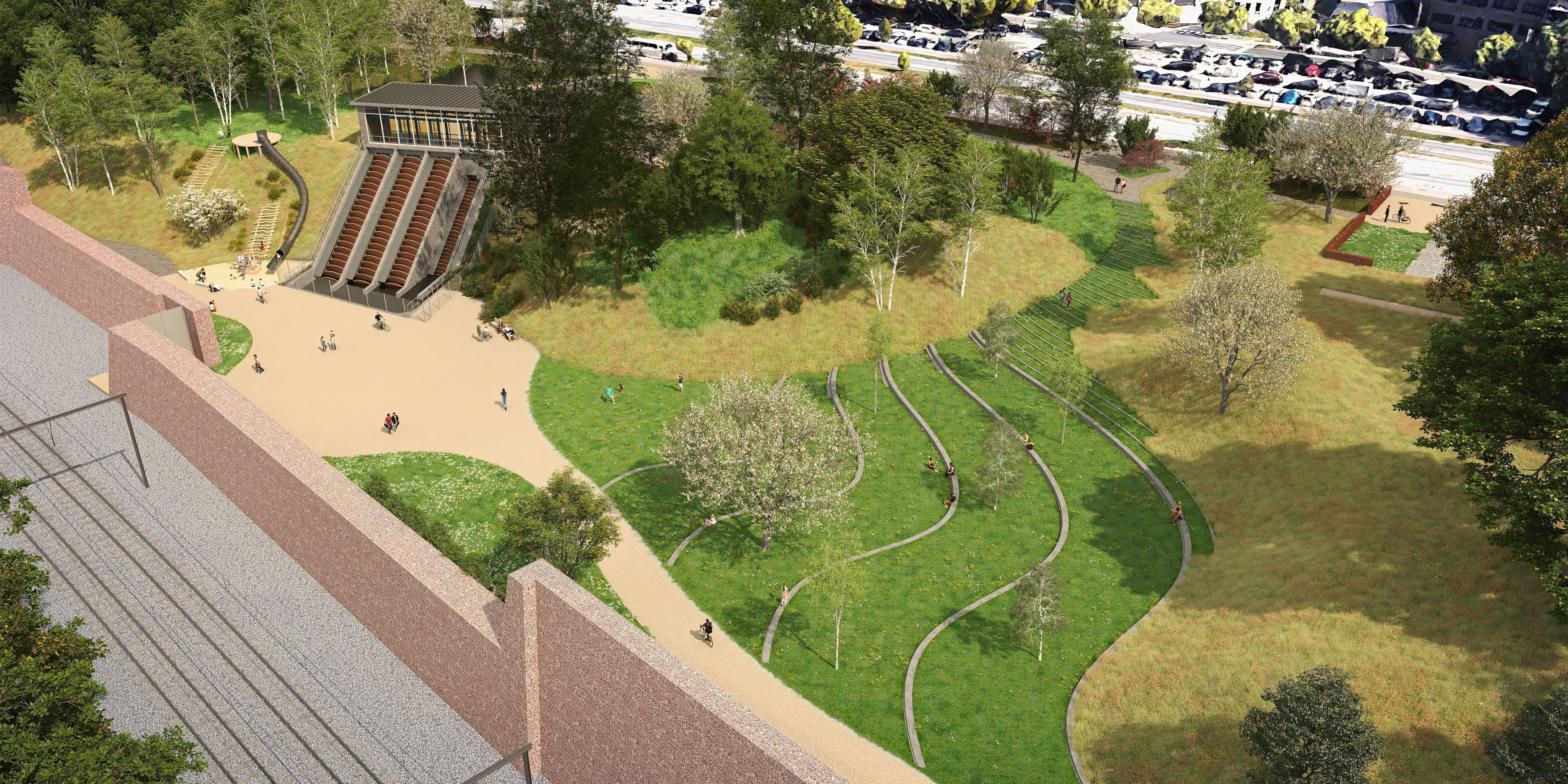 Zicht op het park rond het pompstation en vooraan in beeld de geluidswerende muur naast de spoorweg